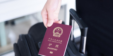 Hand holding China passport, ready to travel